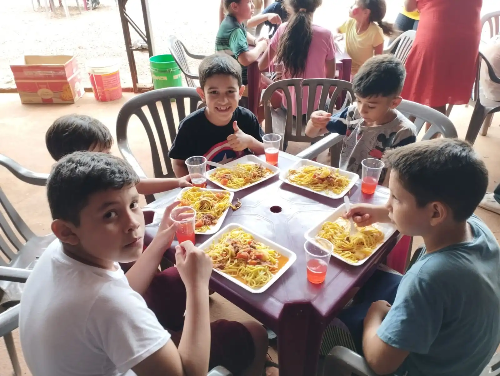 Crianças carentes comendo macarrão