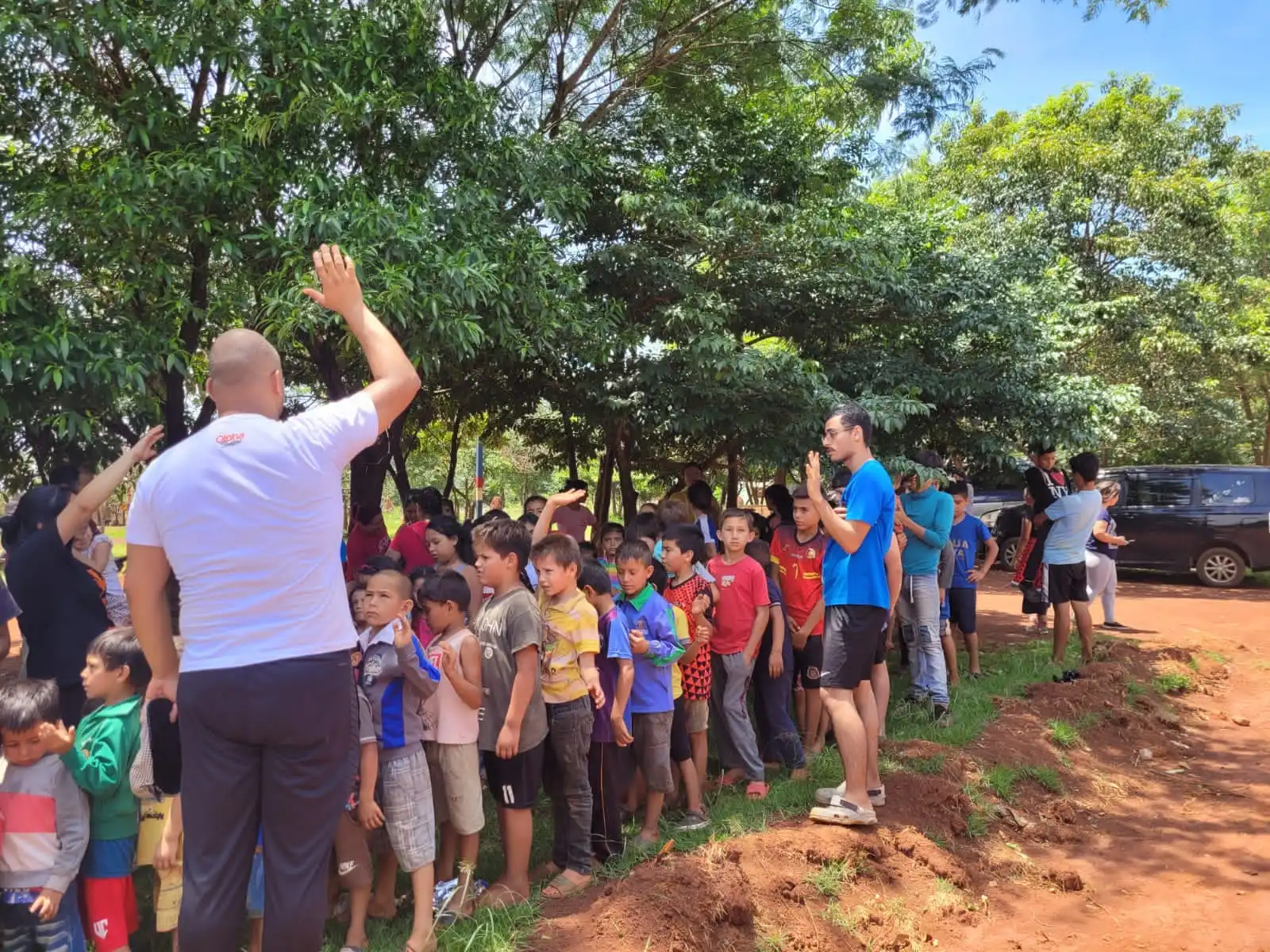 Pastor Eber e voluntários orando com crianças carentes em uma aldeia indigena no Paraguai