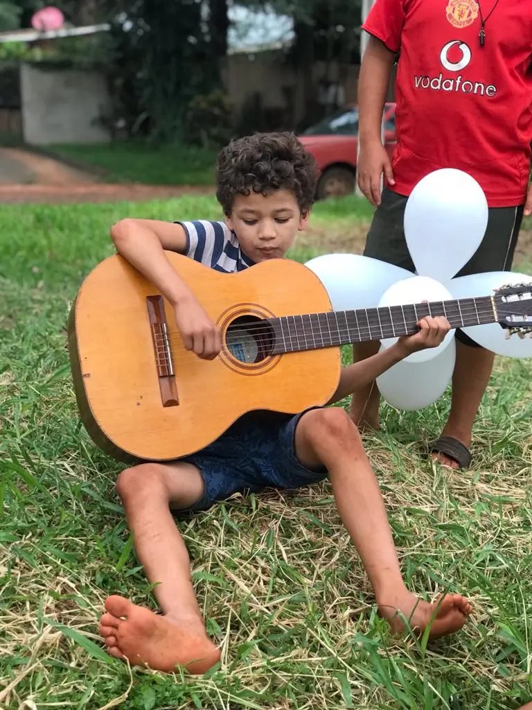 foto formando um circulo com outras fotos de criança tocando violão